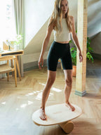 leg&go tasapainolauta ja korkkirulla, soikea 45 x 75 cm, nainen tasapainoilee laudalla kotona