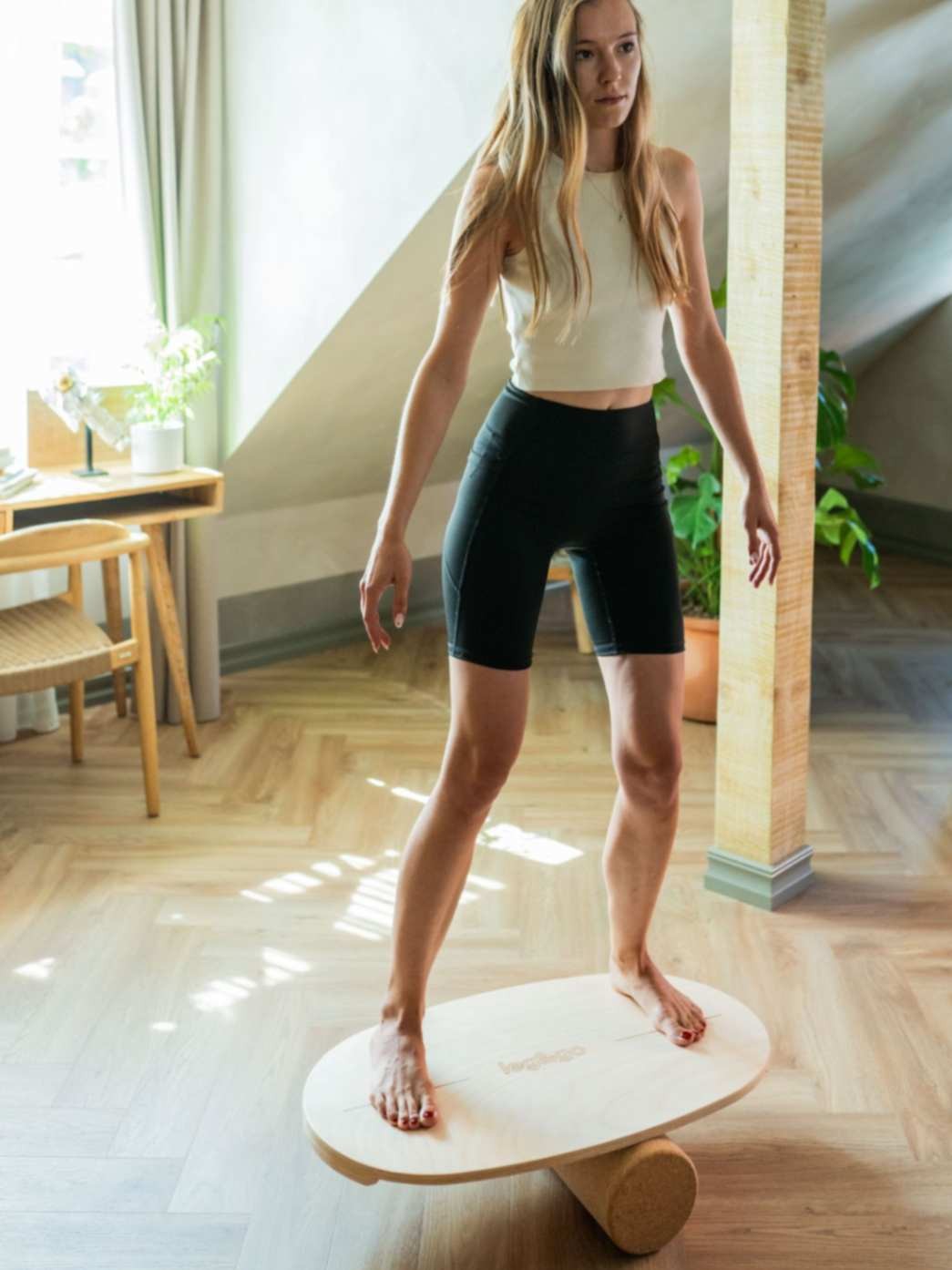 leg&go tasapainolauta ja korkkirulla, soikea 45 x 75 cm, nainen tasapainoilee laudalla kotona